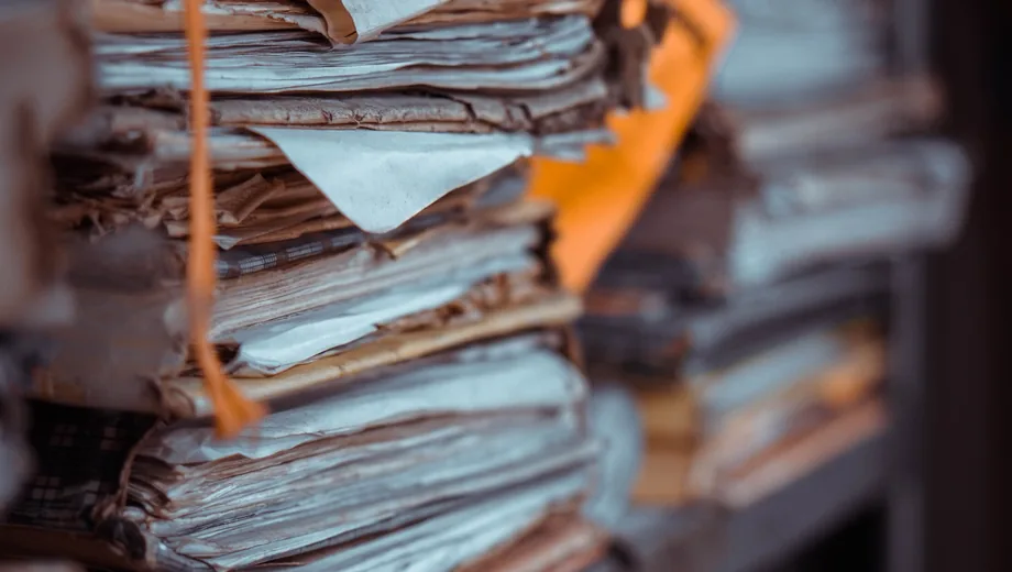 Stacks of paper files creating a back-office bottleneck