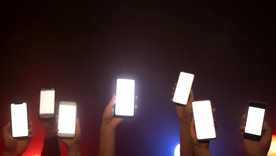 Crowd holding up smartphones during a ticket on-sale surge