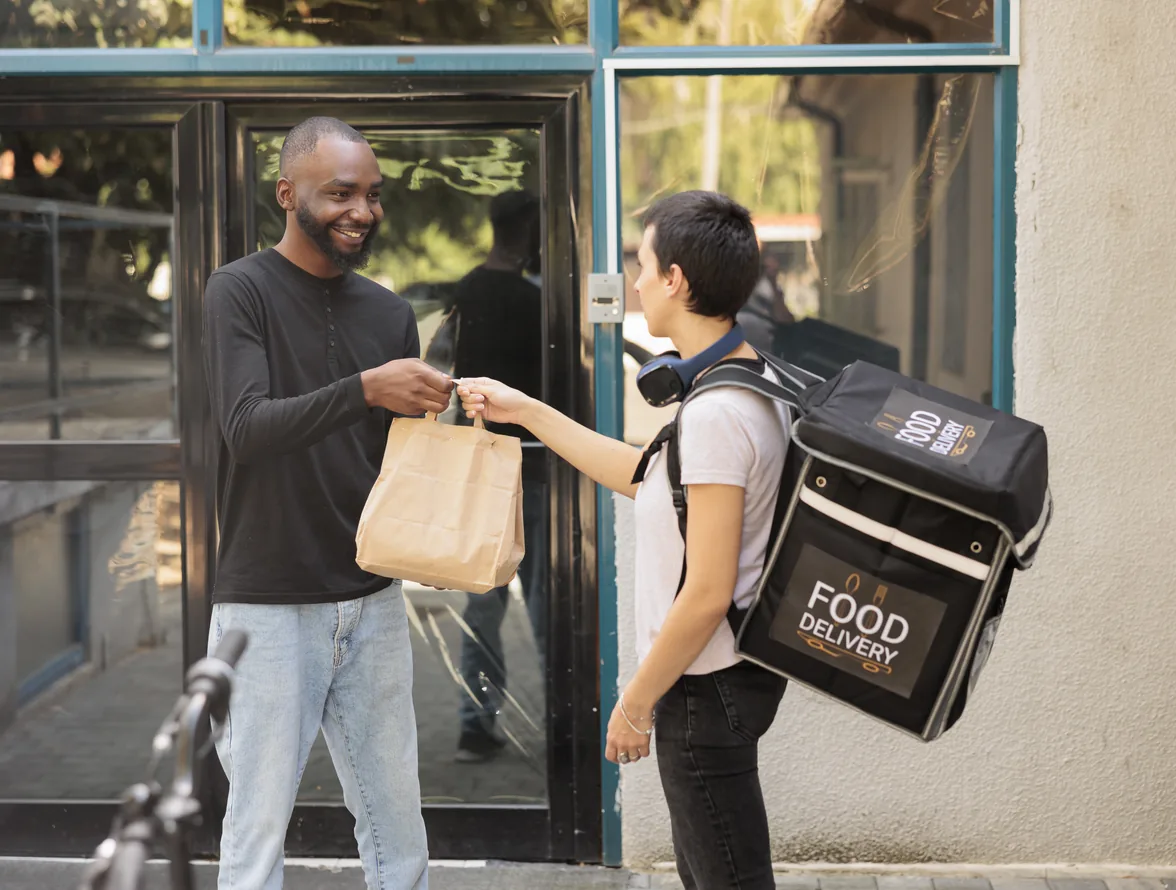 Rider collecting a packed food order from a restaurant counter